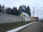 о.п. Дубки: Пассажирская платформа, павильон и забор детского оздоровительного лагеря Юго-Западной железной дороги