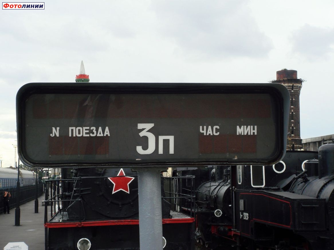 Неработающее табло на фоне экспозиции музея ЖД техники Октябрьской ЖД