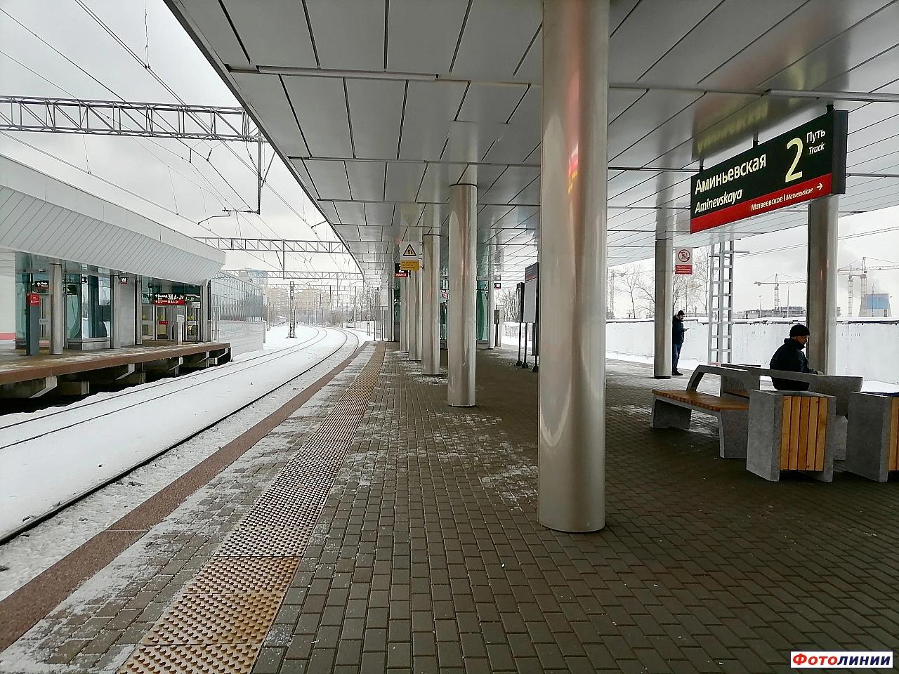 Табличка на  западной платформе и пассажирский вестибюль на восточной платформе, вид в нечётном направлении
