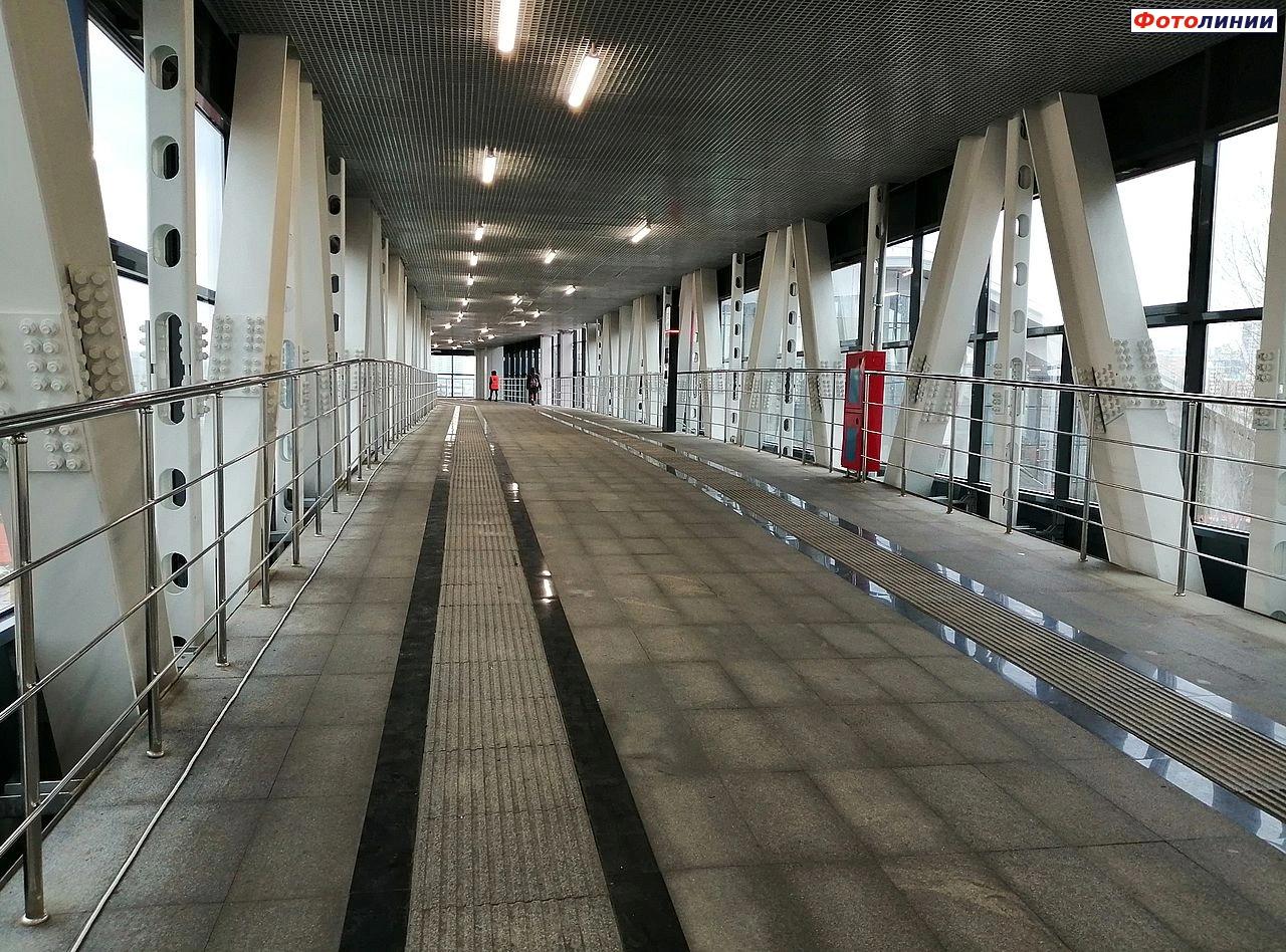 Интерьер пешеходного переходного моста, выход к платформе